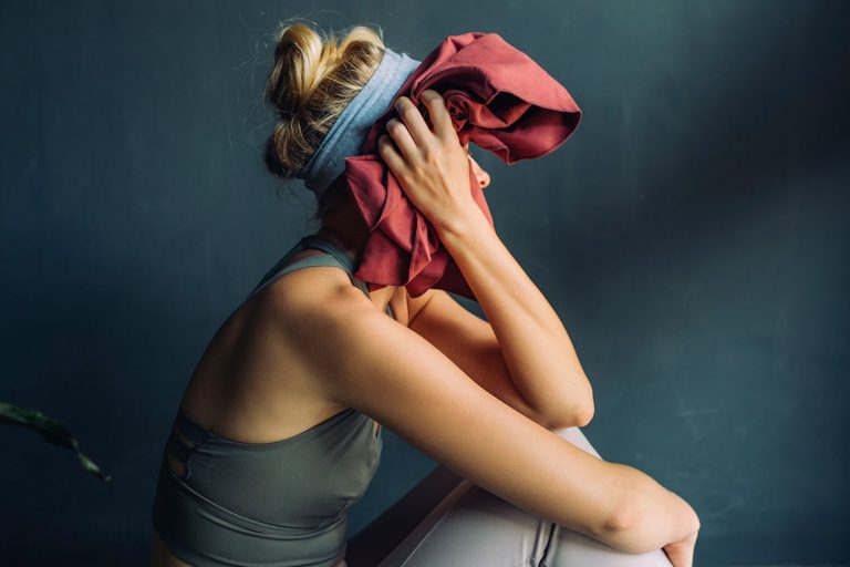 Stock photo of woman sitting on a mat after working out