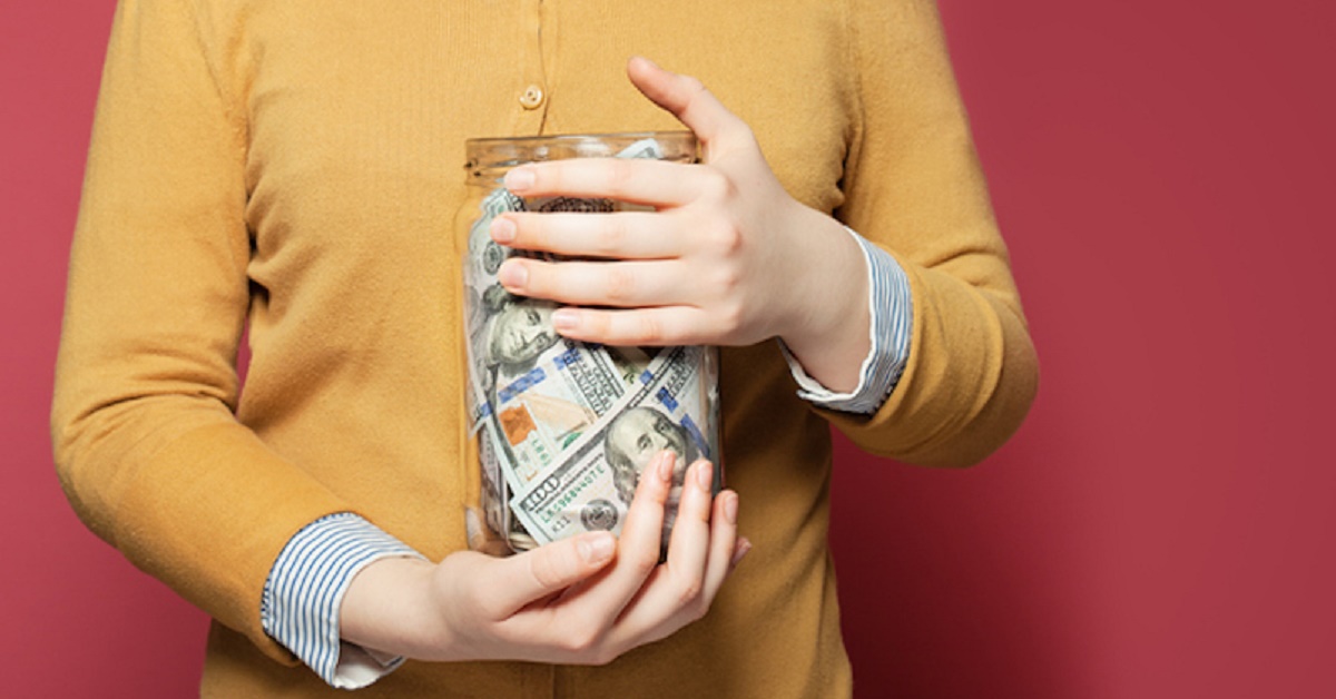 Jar full of money in hands. Saving money concept