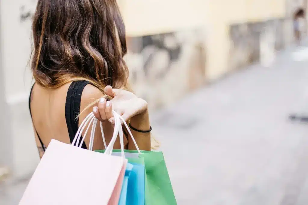 Shopper browsing affordable autumn clothing and accessories on a store shelf with visible price tags