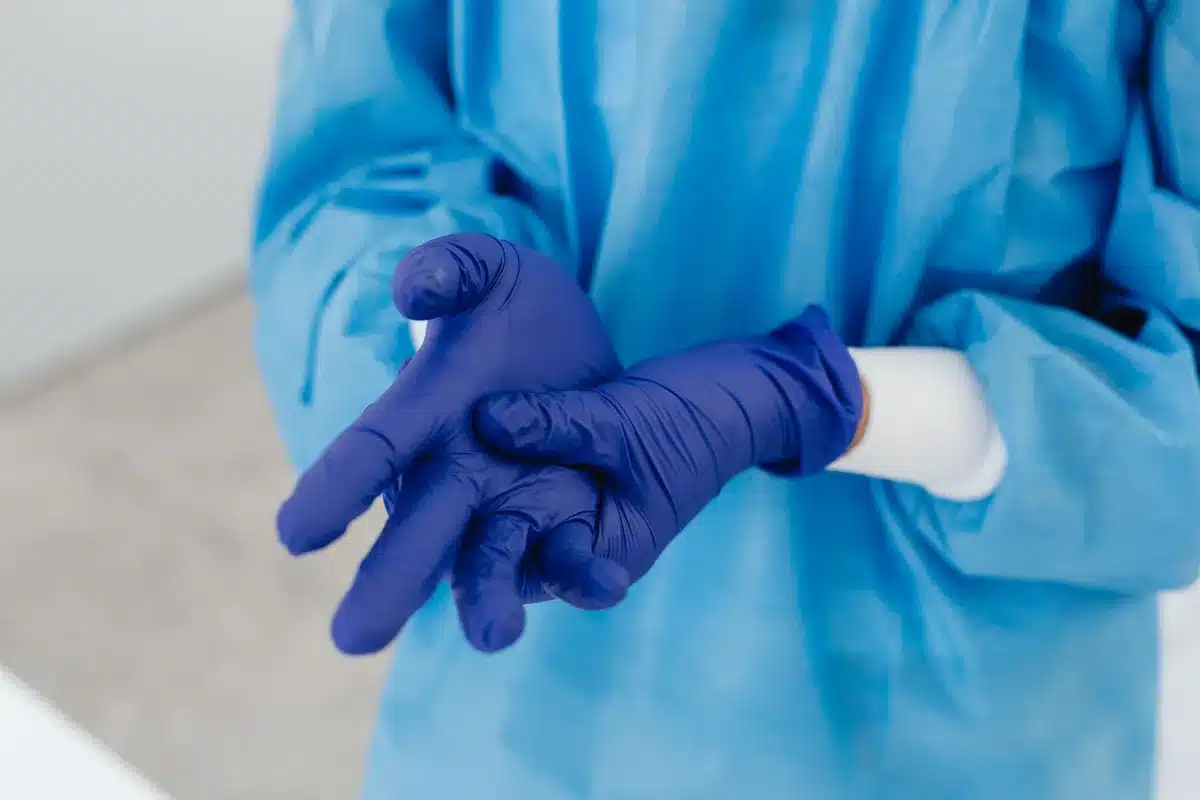 Healthcare worker putting on protective gloves for infection control procedures