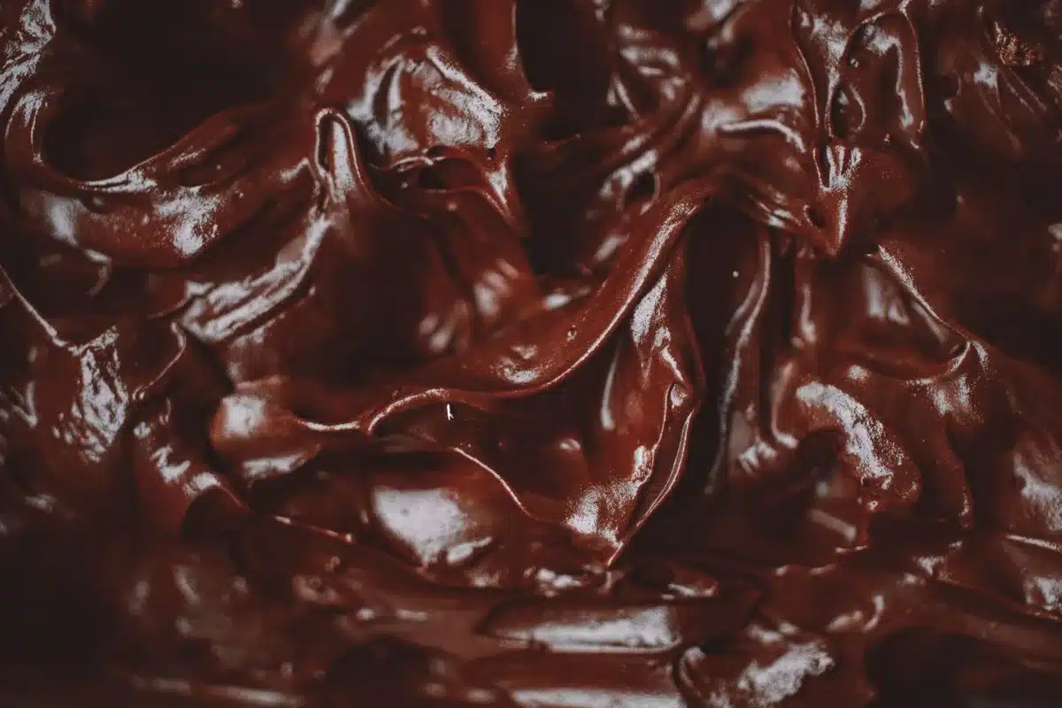 Ganache de chocolate derretido vertido suavemente sobre un postre de brownie enfriado