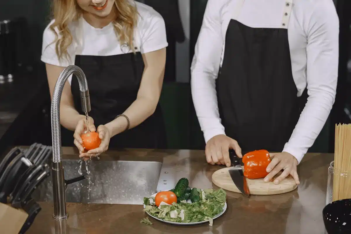 Clean cutting board and utensils being washed in a kitchen sink