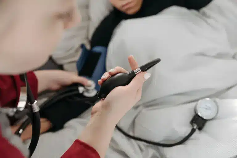 Woman checking blood pressure at home using a digital monitor on her wrist