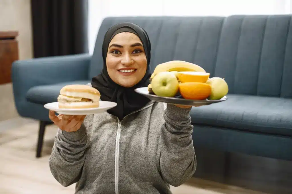 Person pushing away fried food and choosing fresh vegetables and water instead