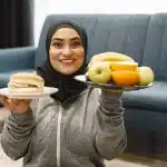 Person pushing away fried food and choosing fresh vegetables and water instead