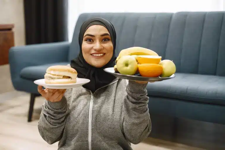 Person pushing away fried food and choosing fresh vegetables and water instead