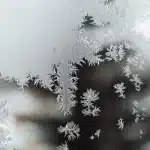 Freezer compartment filled with frost-covered food packages and containers stacked neatly