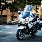 Policewoman on electric bike patrolling busy London street at night