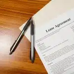 Lease agreement document with pen and calculator on desk, representing new Motability contract terms