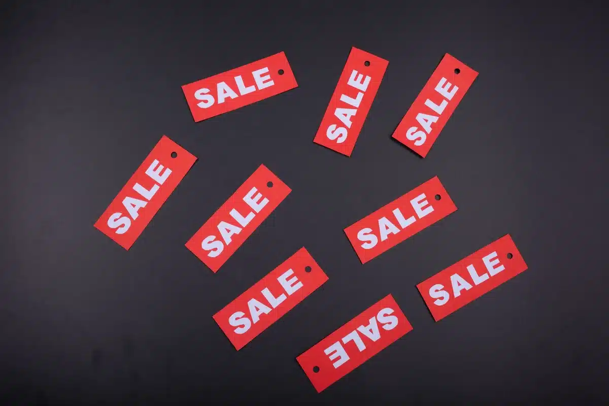 Property listing sign showing price reduction, indicating overpriced homes