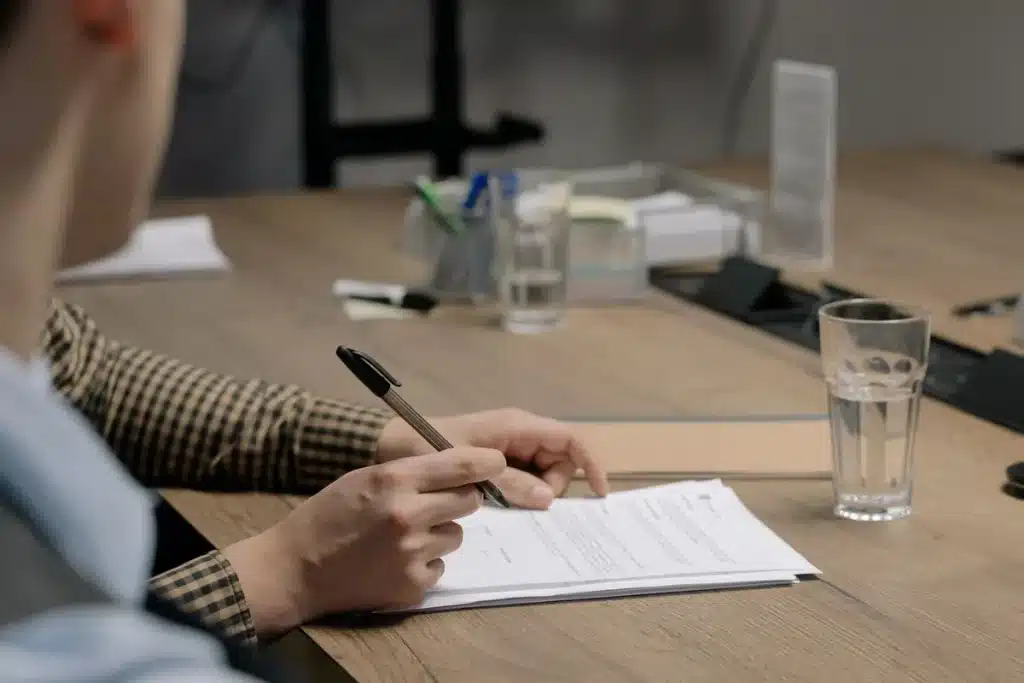 Mortgage paperwork, pen, and house key on a desk during home purchase preparation