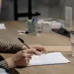 Mortgage paperwork, pen, and house key on a desk during home purchase preparation