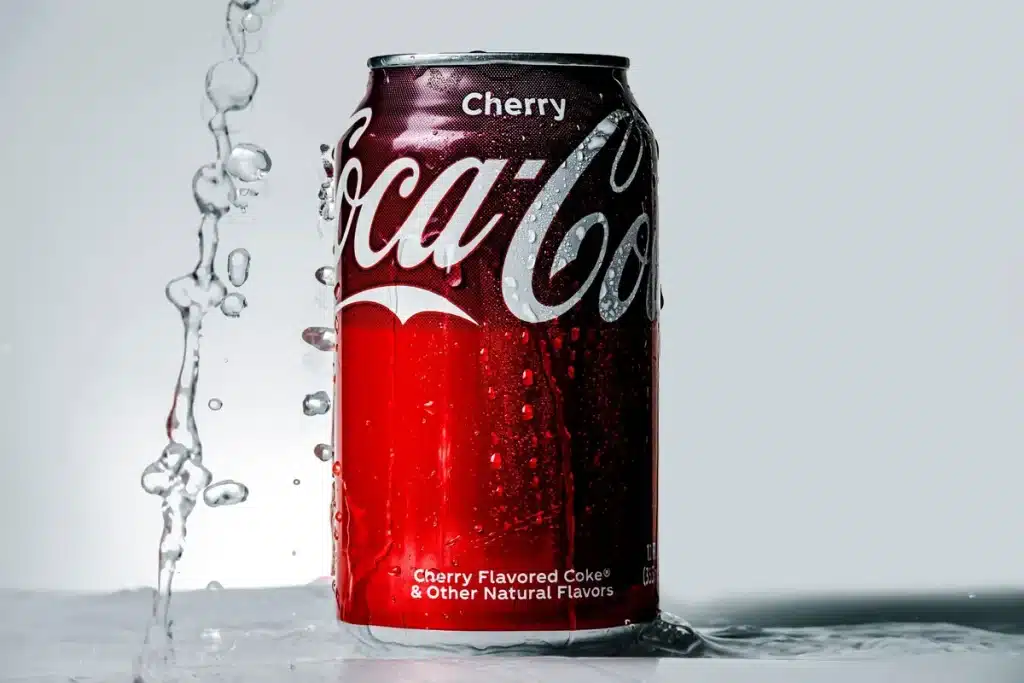 Magnifying glass examining nutrition label on soda can, revealing small print and ingredients
