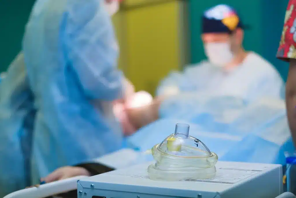 Medical professionals in hospital corridor near surgical suite with equipment