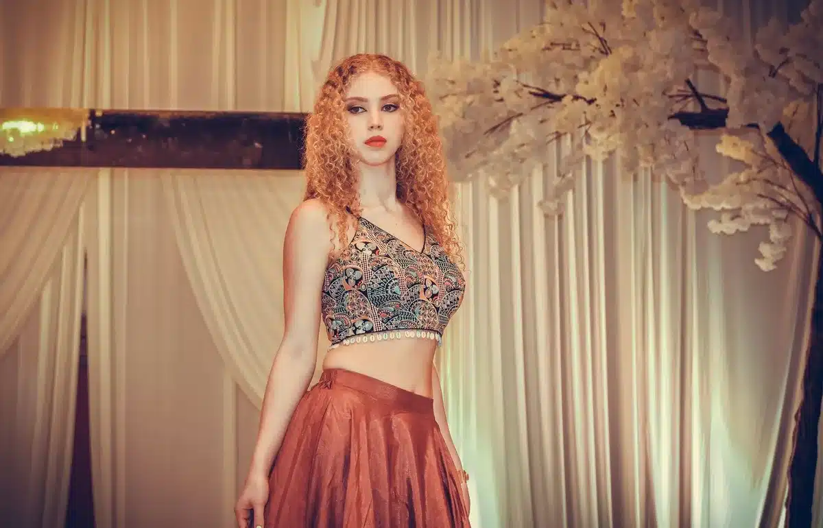 Woman with glossy bouncy ringlets and curtain bangs in country style