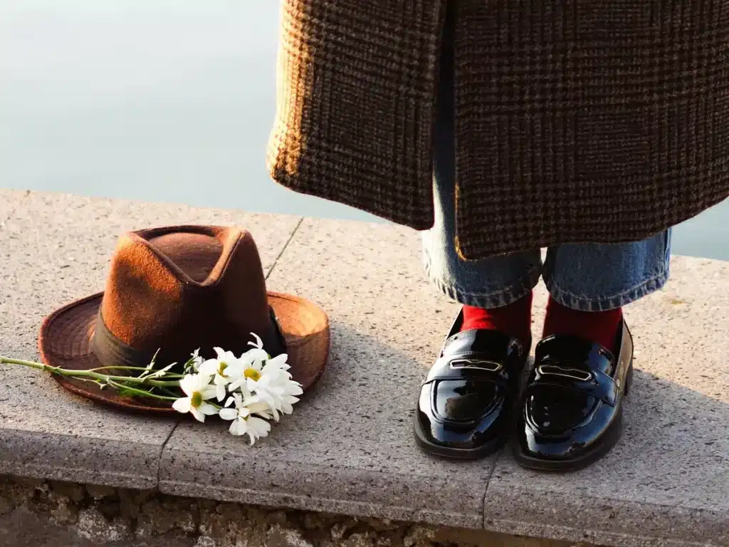 Collezione di scarpe autunnali eleganti e comode, tra cui stivali, mocassini e sneaker su sfondo neutro