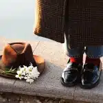 Collezione di scarpe autunnali eleganti e comode, tra cui stivali, mocassini e sneaker su sfondo neutro