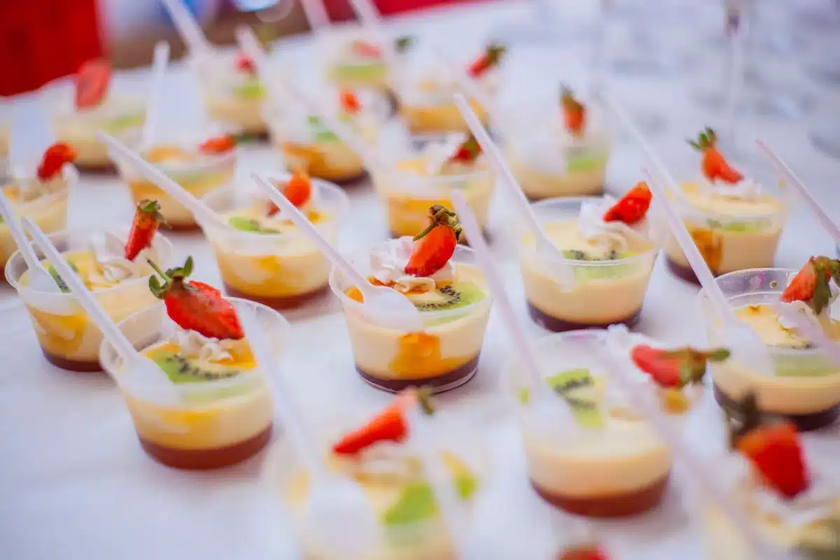 Watergate Salad portioned into individual serving cups with nut and marshmallow garnish