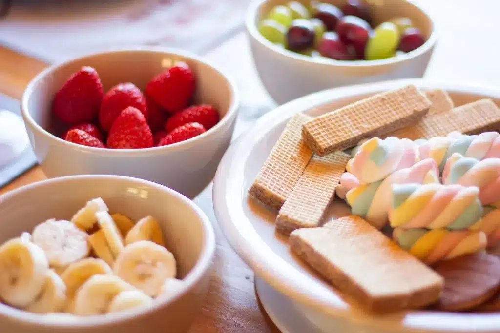 Bright green pistachio pudding salad with marshmallows and nuts in a glass bowl
