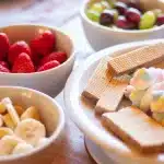 Bright green pistachio pudding salad with marshmallows and nuts in a glass bowl