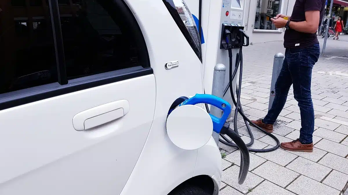 Electric van plugged into a public charging point in urban setting