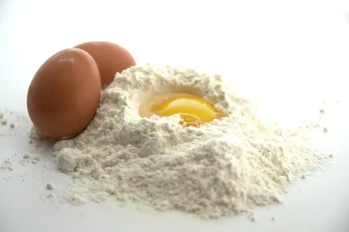 Bowls of flour, eggs and butter arranged for baking the cake