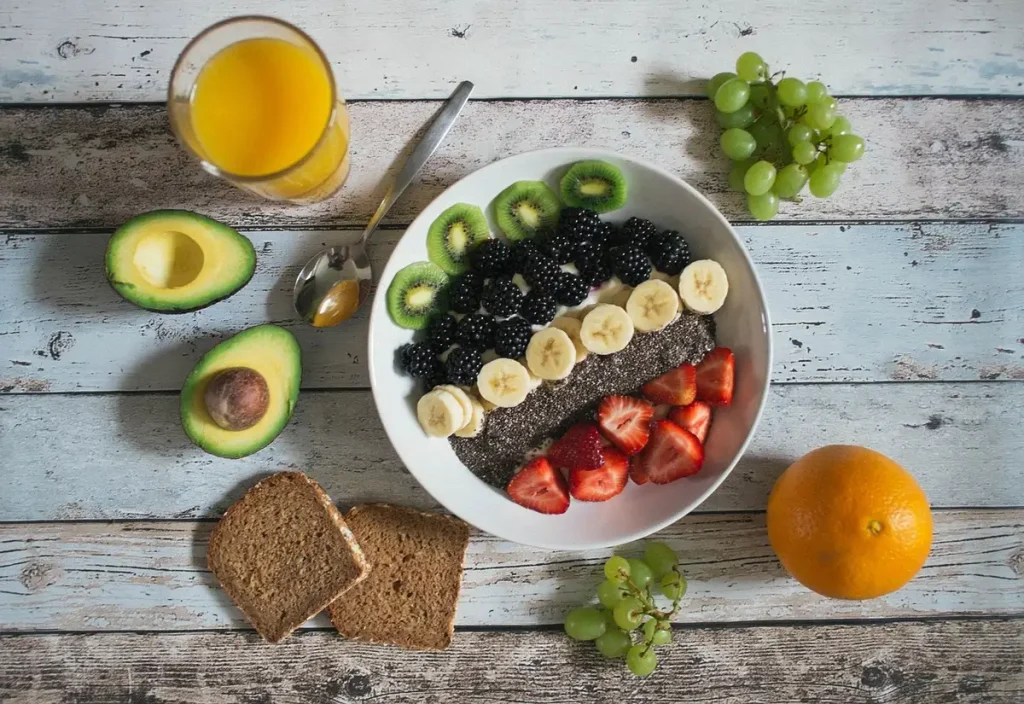 Ripe avocado halves on a plate with fresh vegetables and whole grains