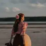 Teen swimmer in shallow tropical water with concerned beachgoers nearby during a marine incident