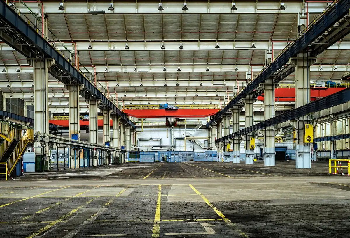 Interior of a car assembly line in a modern factory with workers and vehicles