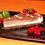 Sliced blueberry cheesecake bars on a plate with fork, showing layered crust, cream filling and berries