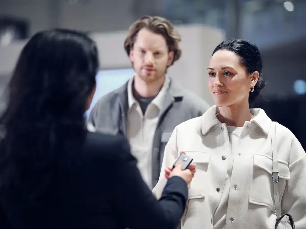 UK car buyers browsing vehicles at a modern dealership