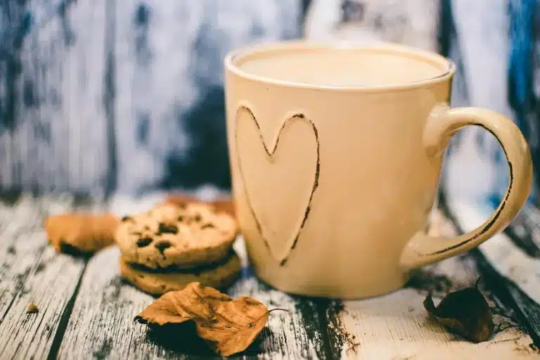Anonymous hand filling a golden cookie cup in a muffin tin with chocolate-hazelnut spread