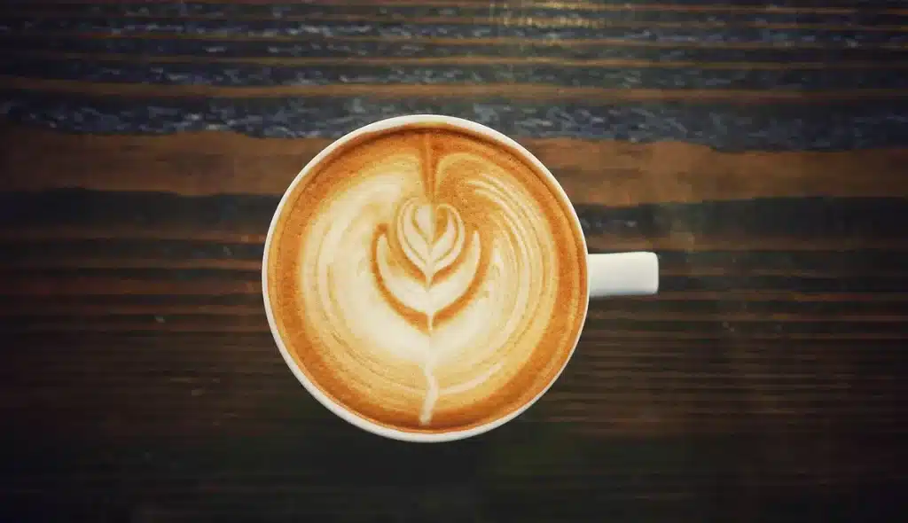 Warm cup of coffee next to medical equipment symbolizing heart health monitoring