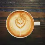 Warm cup of coffee next to medical equipment symbolizing heart health monitoring