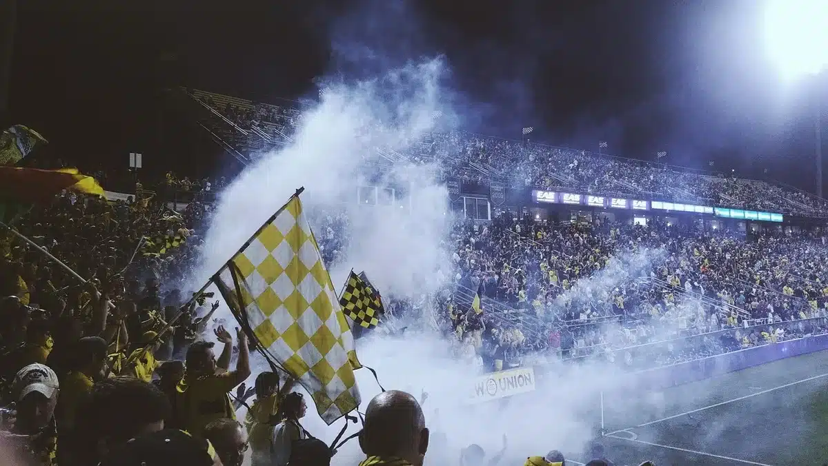 Sports fans holding custom banners and wearing team badges in stadium