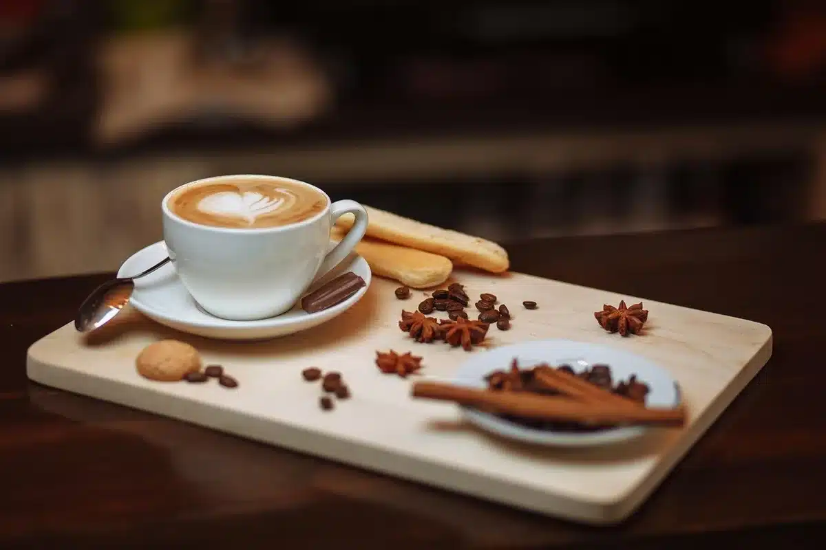 Hand placing a lid on a mug and a timer on a kitchen counter