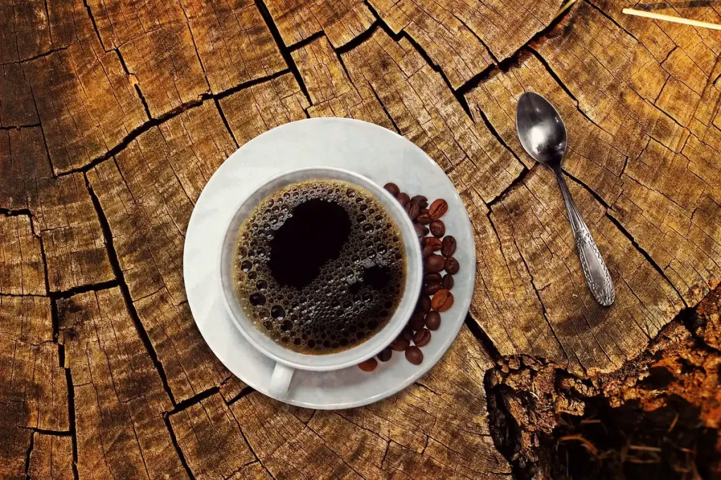 Daylit kitchen table with a hot cup, hand and thermometer to check temperature