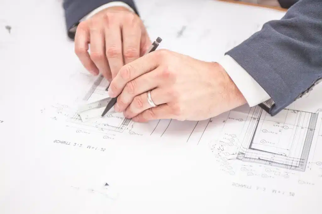 Anonymous hands holding an injector pen during a clinic consultation, notebook and glass on table