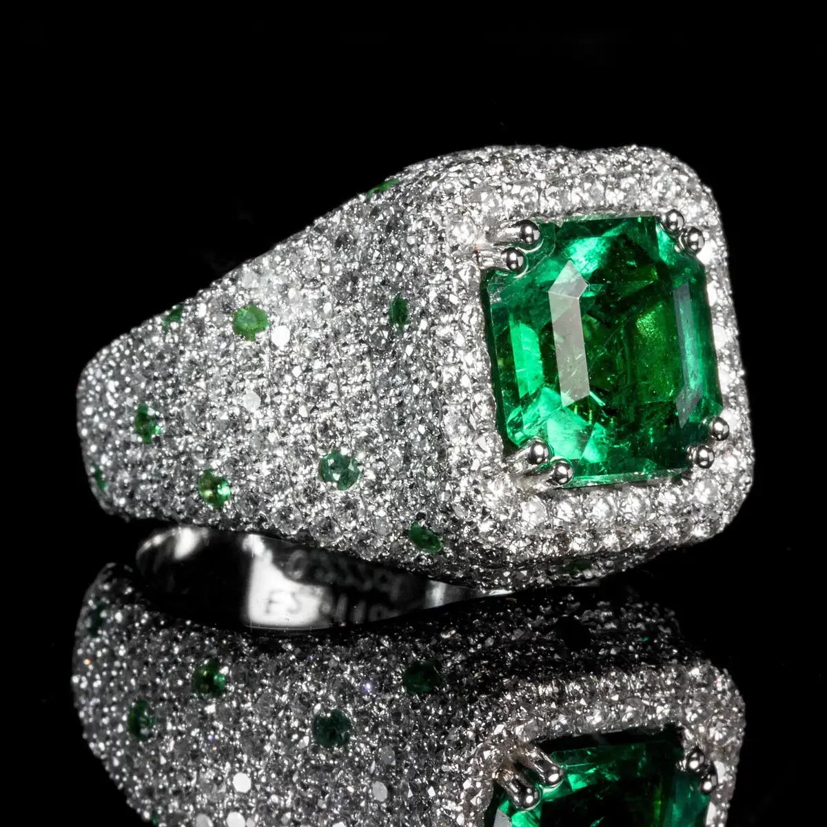 Close-up of a vintage-style ring with matching diamond and emerald stones