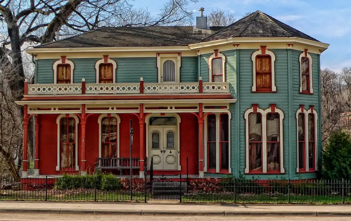 Exterior of a Victorian house in bright daylight with a tidy front yard
