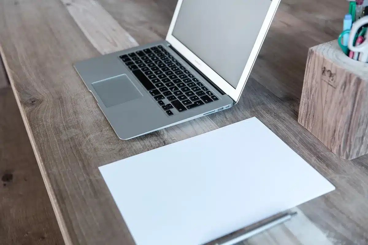 Structured tote beside a laptop and notebook on a bright desk