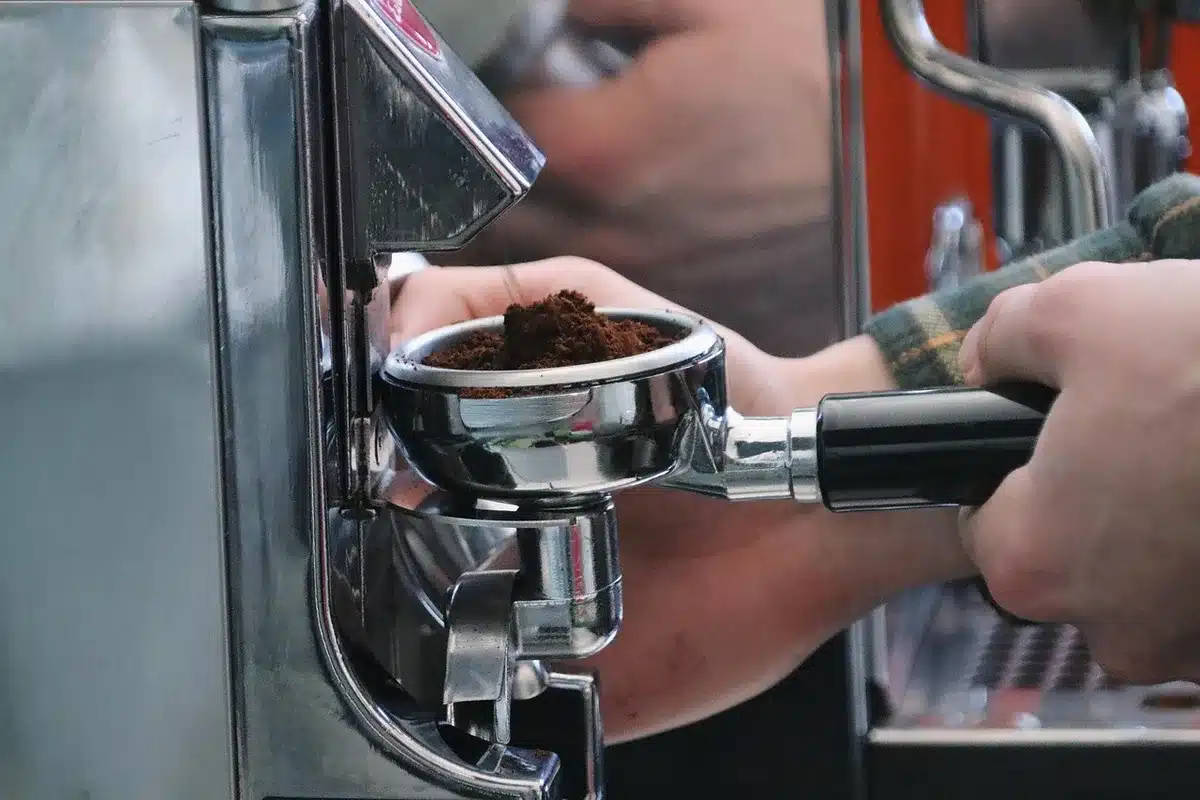 Person ordering coffee at a bright café counter