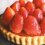 Sliced orange tart with glossy glaze and fresh citrus garnish on a plate