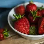 Sliced strawberry cake with fresh berries and vanilla ice cream on a plate