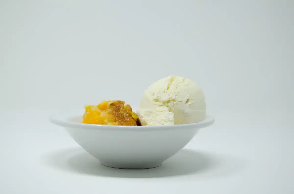 Golden peach cobbler in a baking dish, showing how easily the recipe adapts to other stone fruits