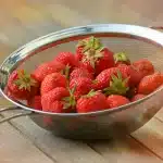 Warm strawberry cobbler in a baking dish with golden crust and bubbly edges, just out of the oven