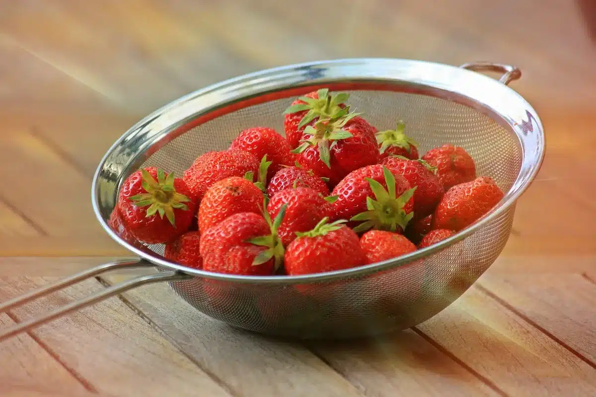 Warm strawberry cobbler in a baking dish with golden crust and bubbly edges, just out of the oven
