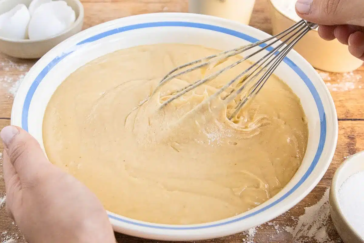 Cake batter being poured into a greased 9x13-inch baking pan