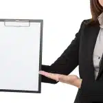 Sunlit clinic reception with hands holding a health screening form on a clipboard