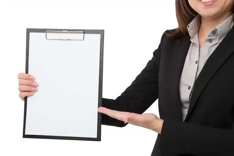Sunlit clinic reception with hands holding a health screening form on a clipboard